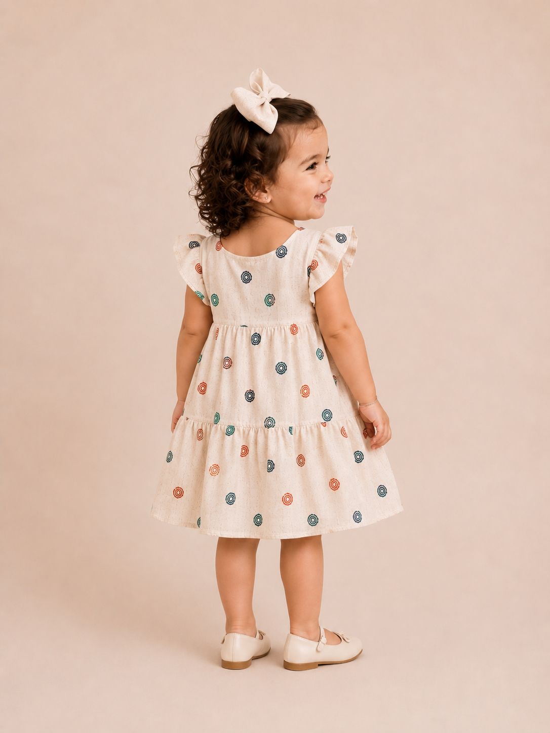 Vestido infantil bege com estampa de bolinhas coloridas e babado