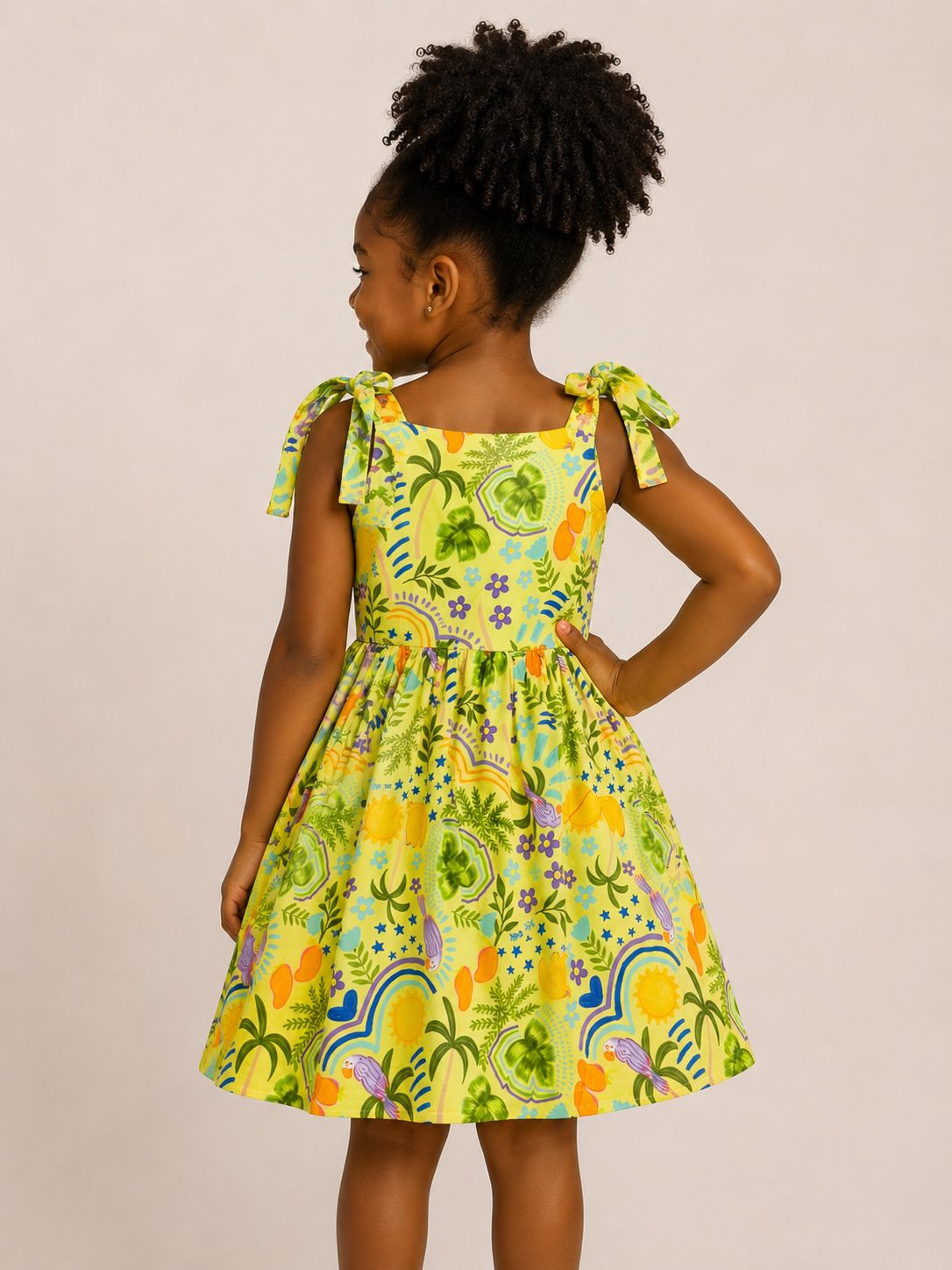 Vestido infantil amarelo com estampa tropical e alças de amarrar